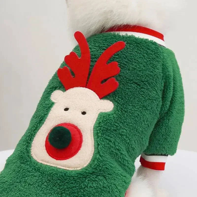 Small dog wearing green winter Christmas hoodie with red reindeer design and pom pom nose