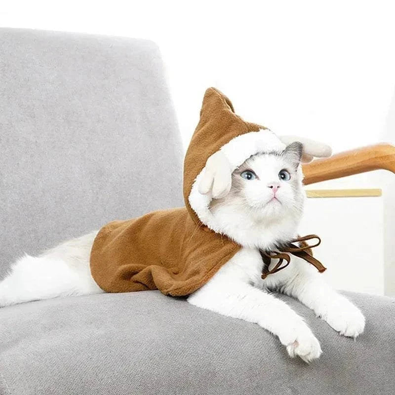 White cat wearing a brown funny cat Christmas costume with hood and tie on gray chair